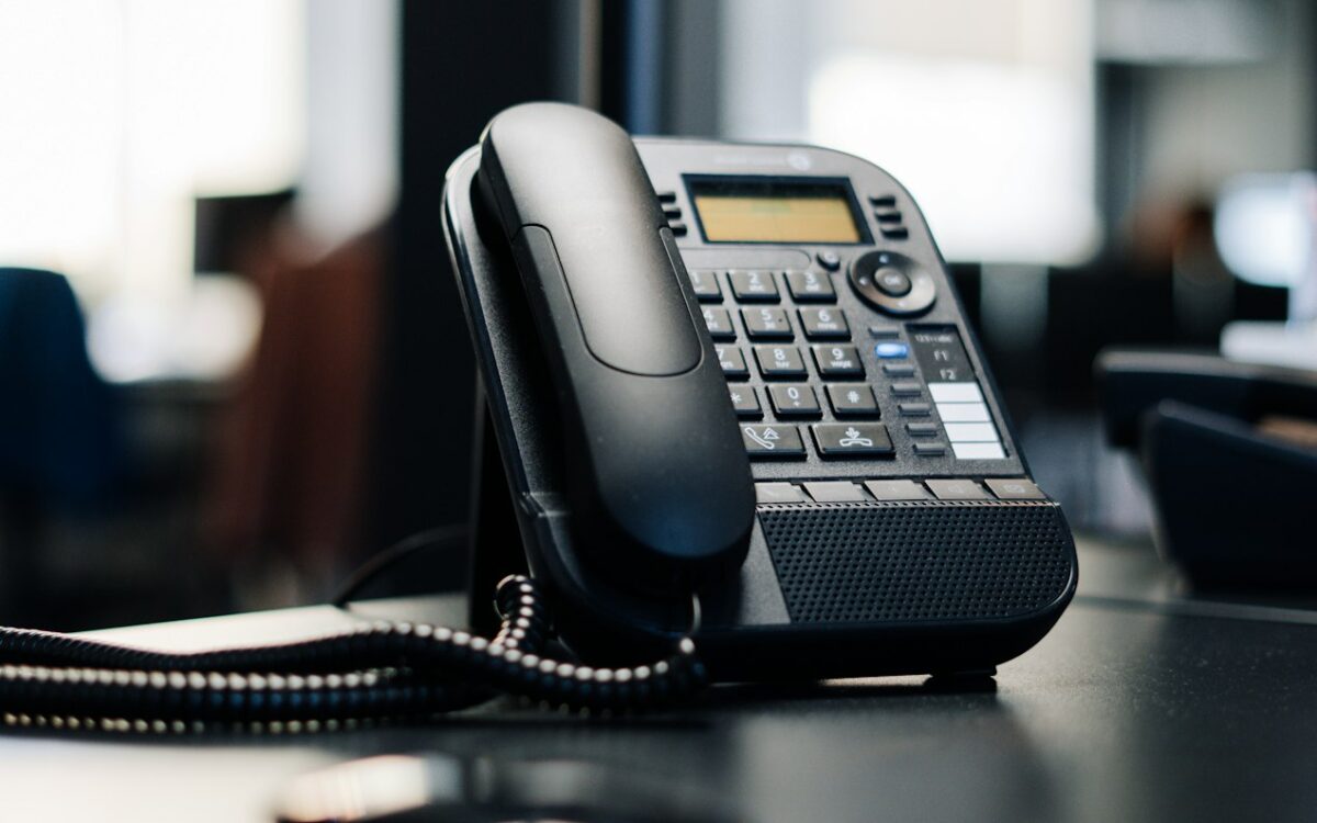 Black IP desk phone on an office desk